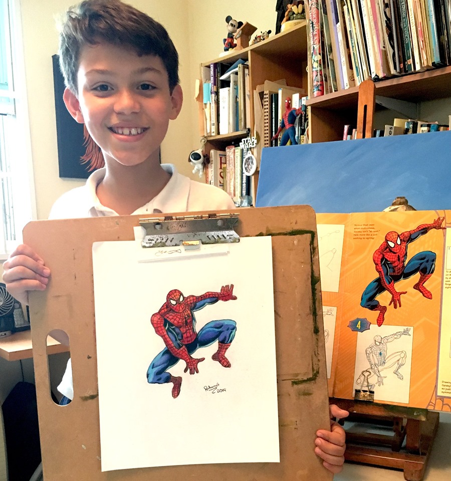 Student Radames showing his Spiderman made in colored pencils