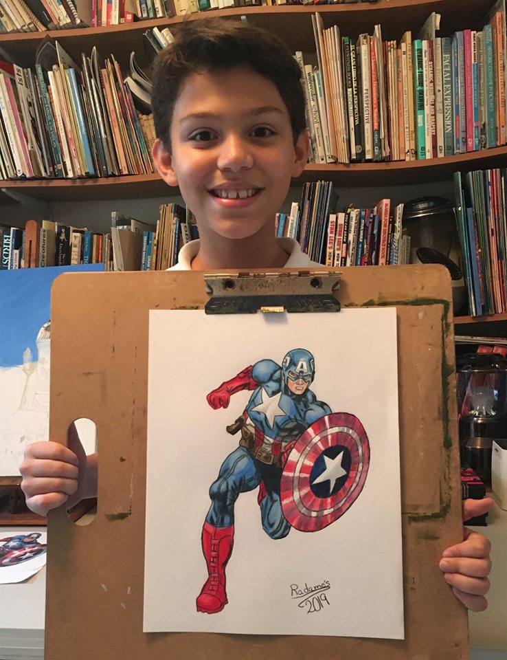 Student Radames showing his Captain America made in colored pencils